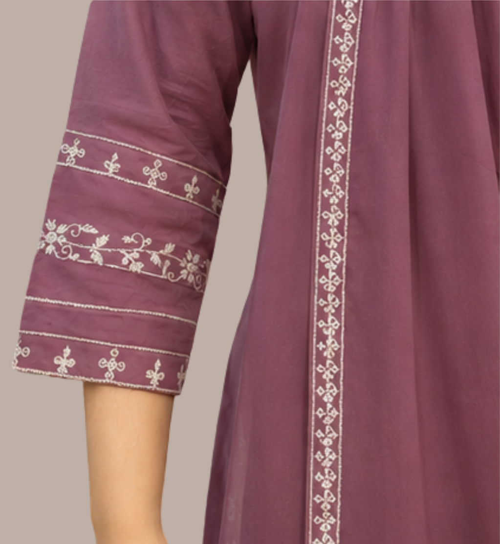 A close-up of a mauve-colored traditional tunic or kurta with white embroidered detailing on the sleeve cuffs and a vertical border, shown on a model against a solid beige background.